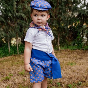 raje flamenco infantil  con pantalón azul de lunares y camisa blanca.