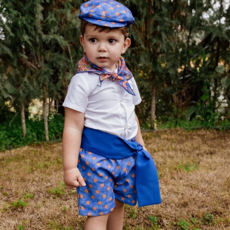 raje flamenco infantil  con pantalón azul de lunares y camisa blanca.