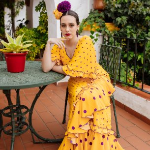 batas rocieras de la colección 2026, con diseño de lunares morados sobre amarillo.