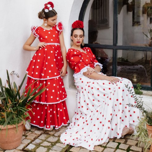 Detalle de la blusa del conjunto rociero, cruzada y anudada a la cintura, con mangas de farol y encaje blanco tradicional.