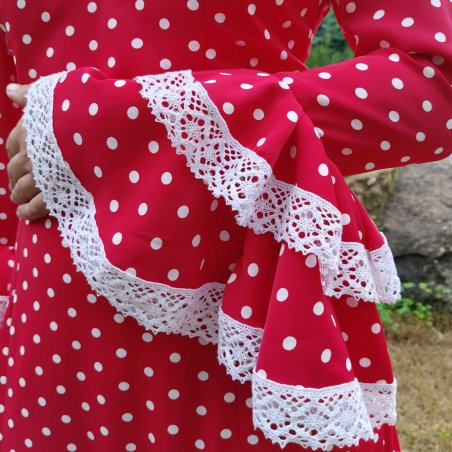 Detalle de encaje de bolillo blanco en manga de traje de flamenca artesanal - Confección propia en Granada