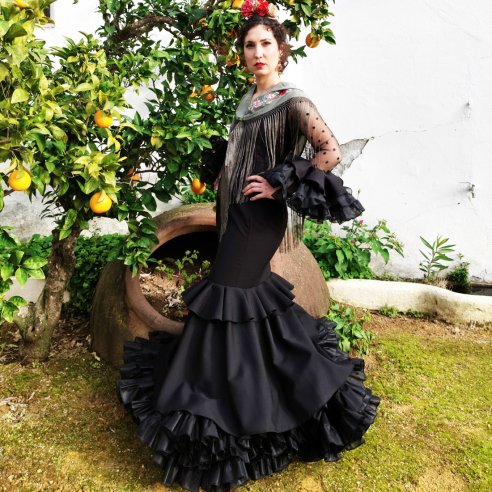 La elegancia absoluta de un traje de flamenca negro azabache: diseño de Carmen Garrido para noches de feria inolvidables.