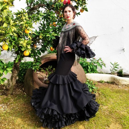 La elegancia absoluta de un traje de flamenca negro azabache: diseño de Carmen Garrido para noches de feria inolvidables.